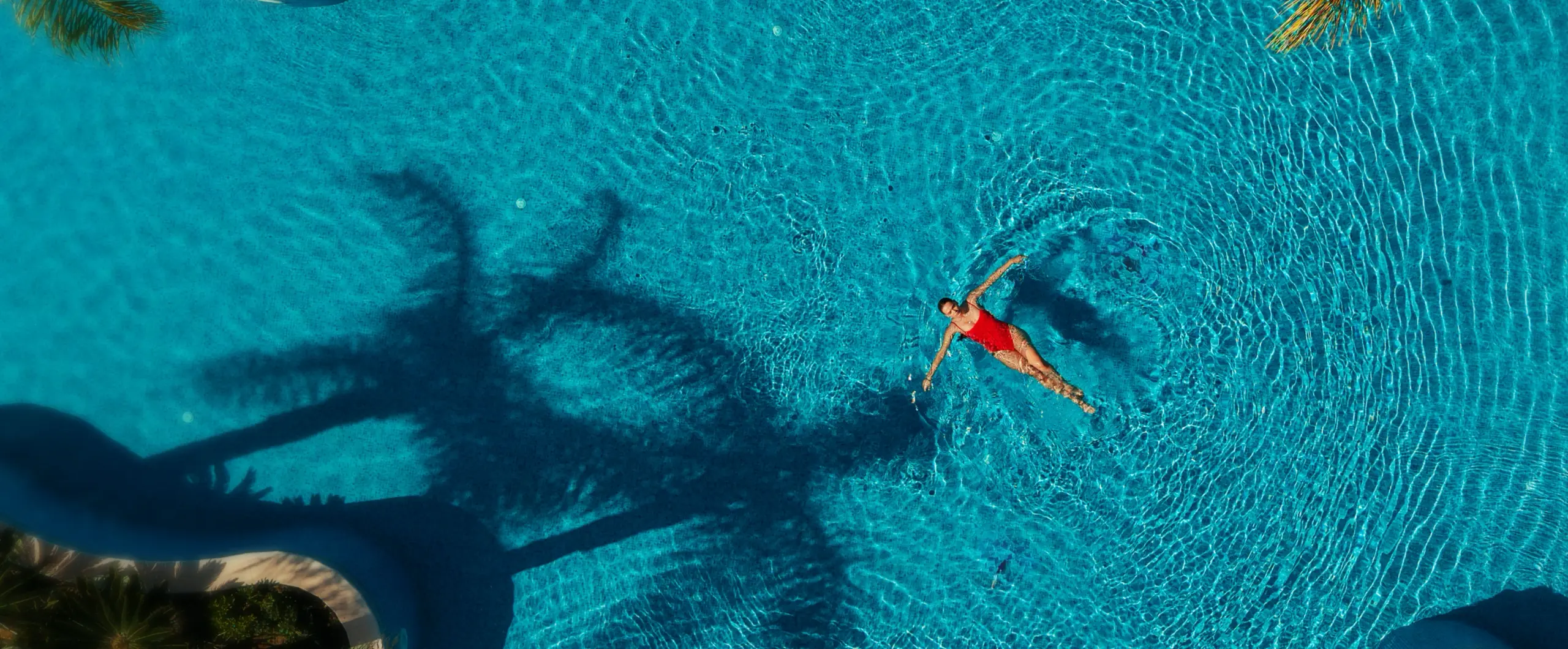Woman relaxing in the lagoon-style pool at Olympic Lagoon Resort Paphos following the resort renovation.
