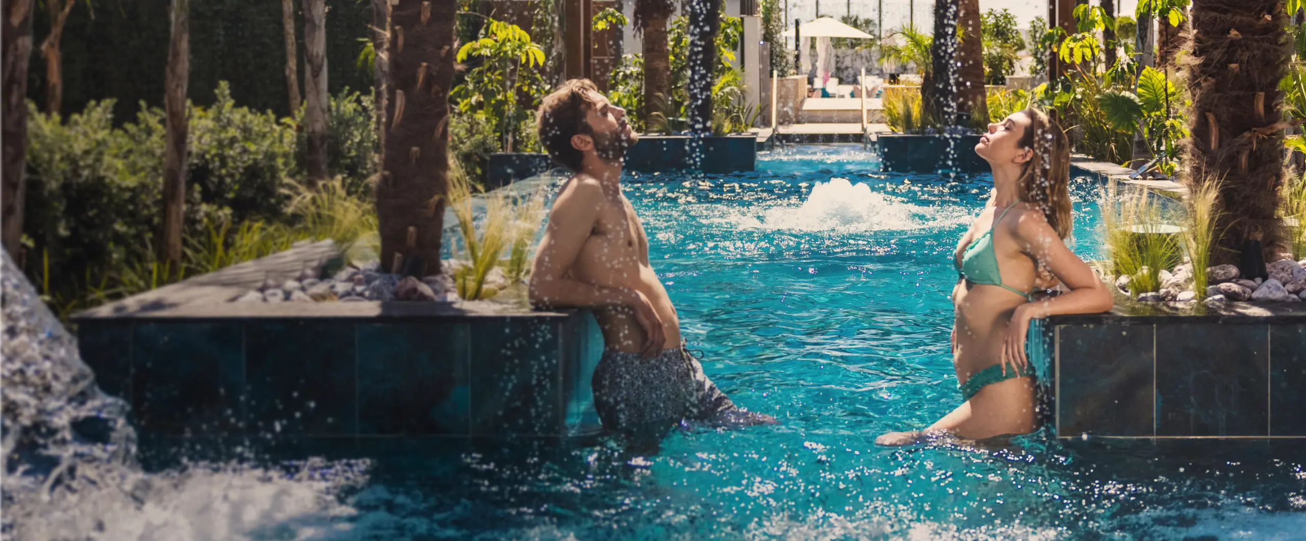 Outdoor pool with couple relaxing in hydro-massage water at Amanti MadeForTwo Hotels